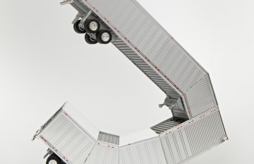 Chrome-colored HO scale model parts of a toy truck merged with shipping containers
