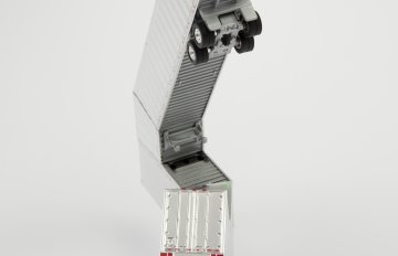 Chrome-colored HO scale model parts of a toy truck merged with shipping containers