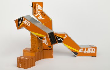 Orange-colored HO scale model parts of a toy truck merged with shipping containers