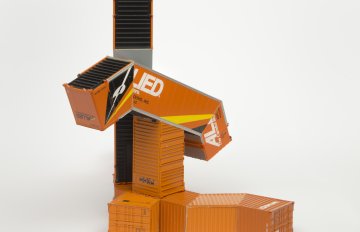 Orange-colored HO scale model parts of a toy truck merged with shipping containers