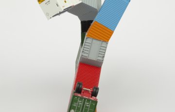 Multi-colored colored HO scale model parts of a toy truck merged with shipping containers