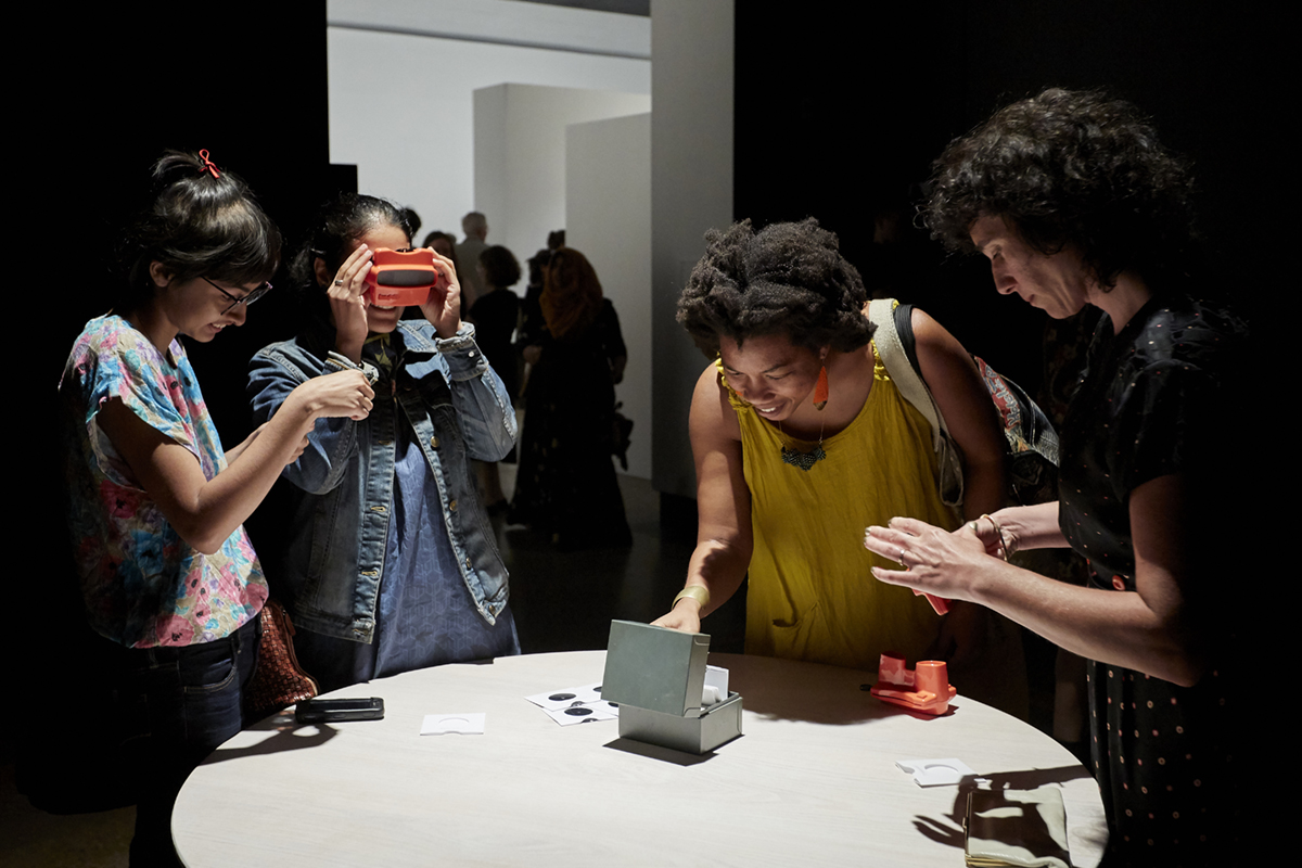 Four women look through Viewmaster slides in Aislinn Thomas' installation at KWAG in 2018