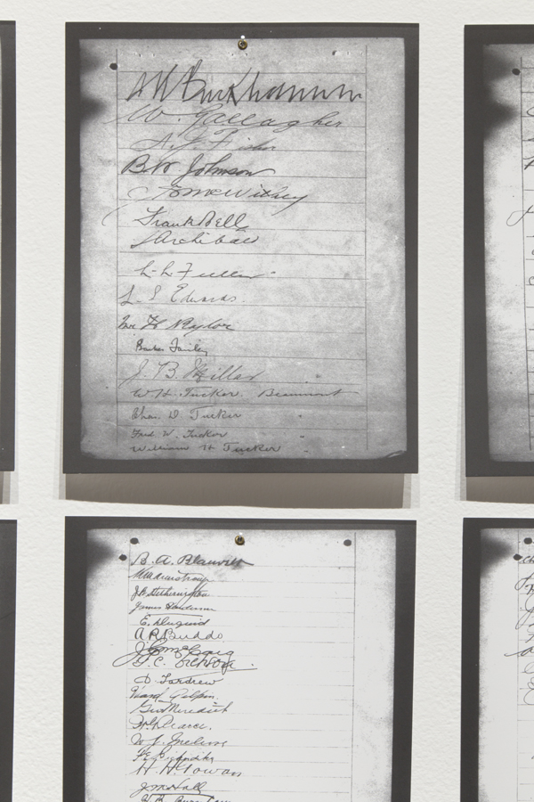 Close-up view of two petition pages revealing cursive signatures in a variety of hands
