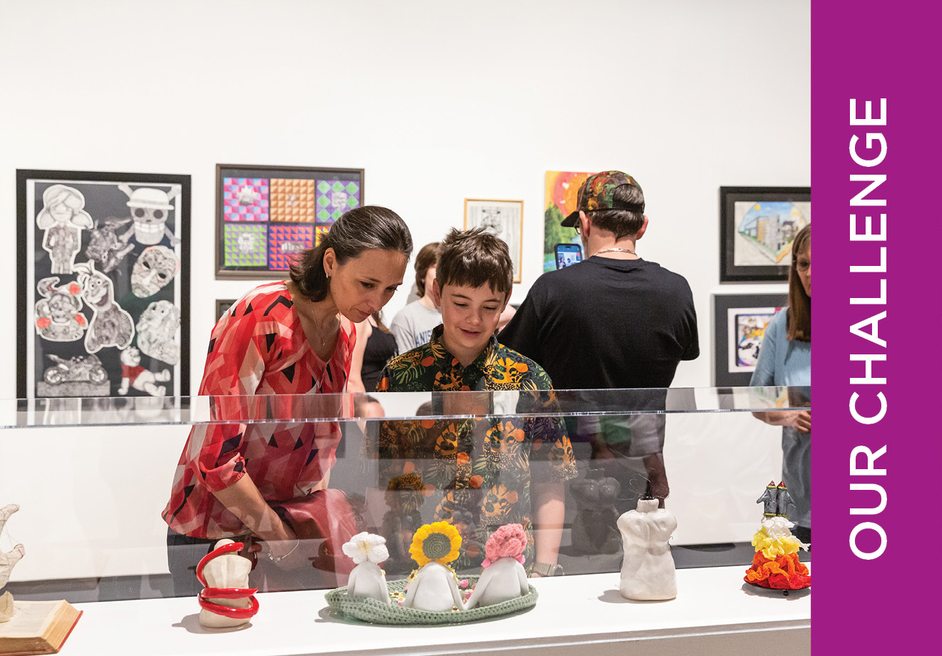 Color photo of a group of people examining an artwork on a plinth during the Expressions exhibition
