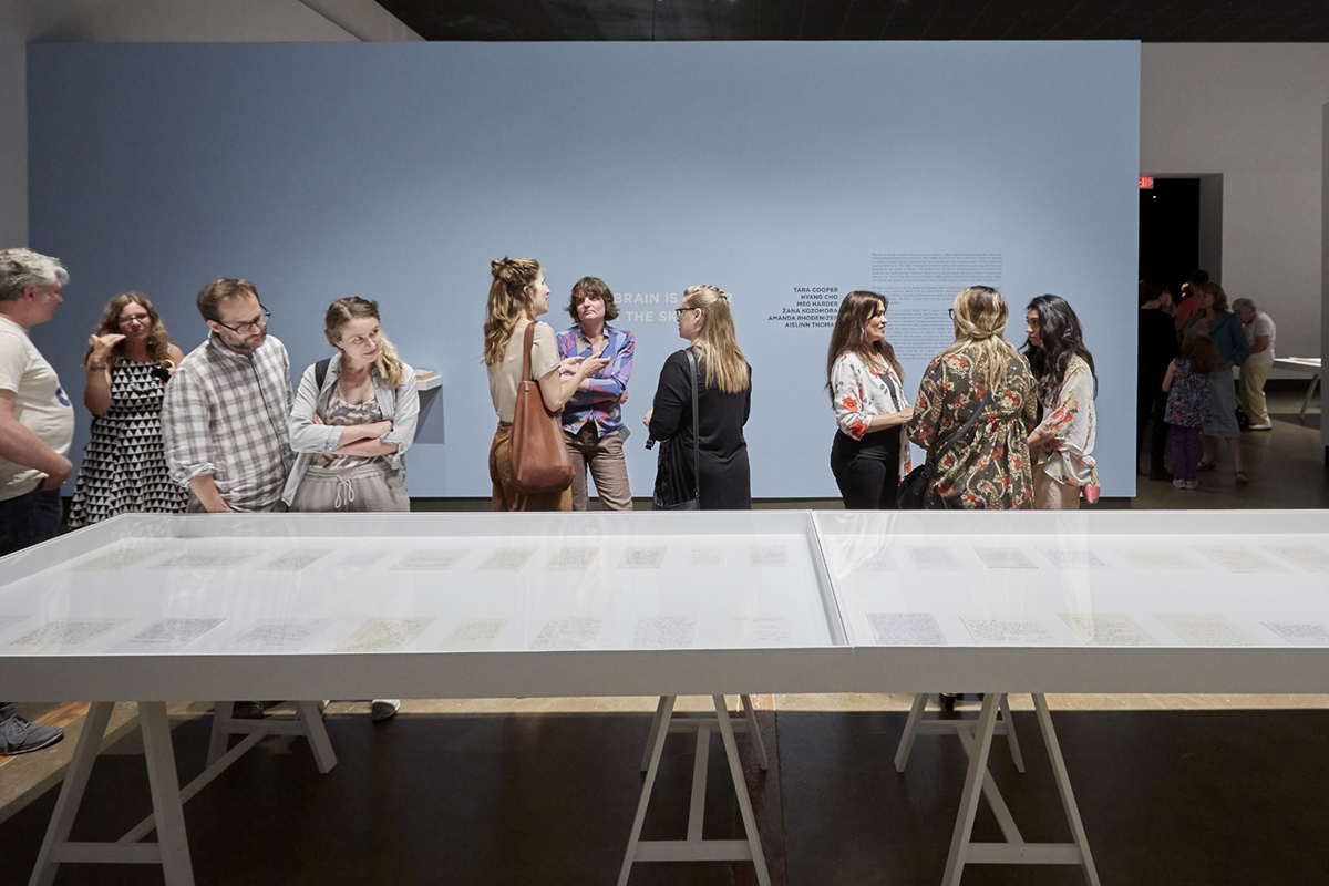 A group of people gathered in small groups talking in the Main Gallery