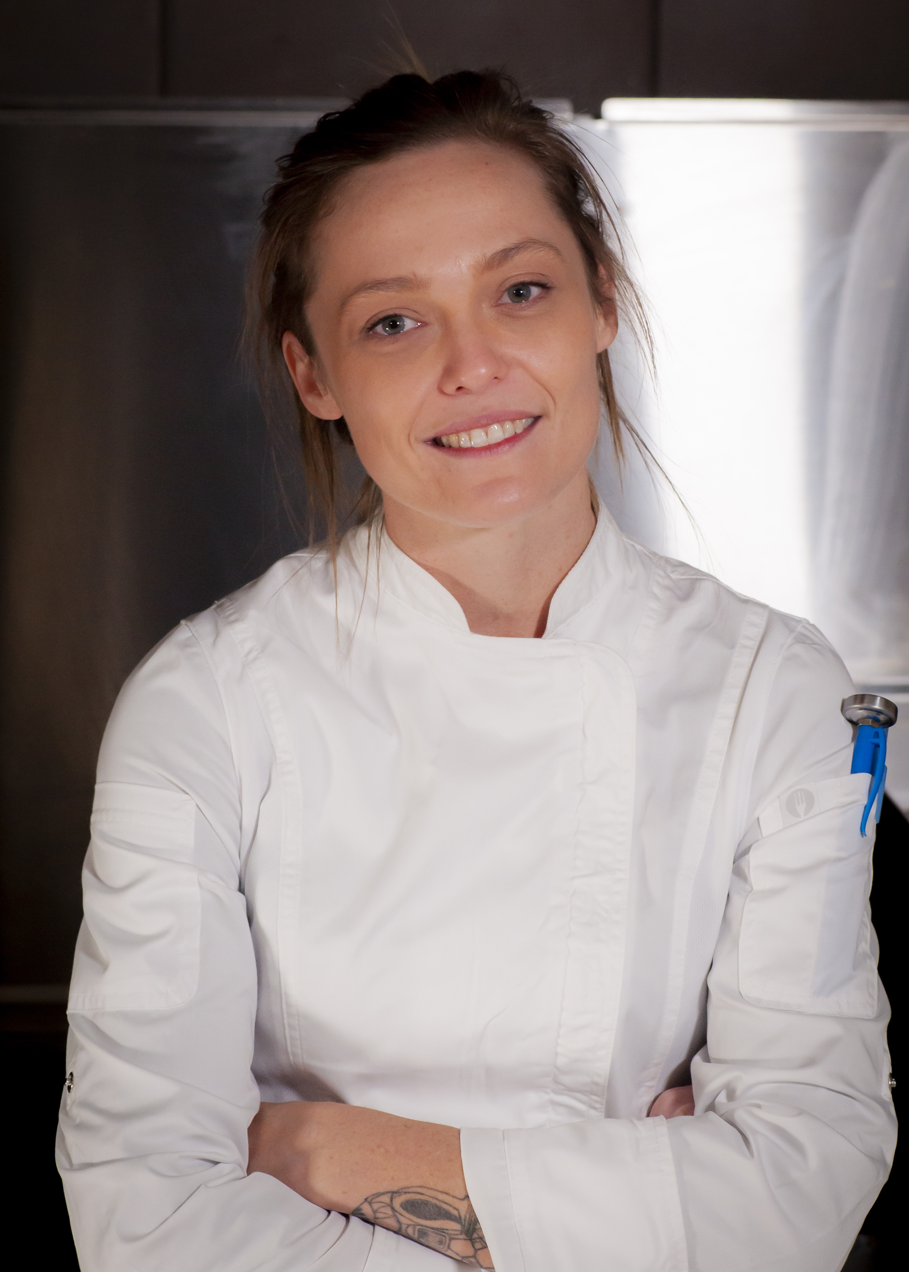 Photo of Kay Miller, a smiling white woman wearing a chef's jacket