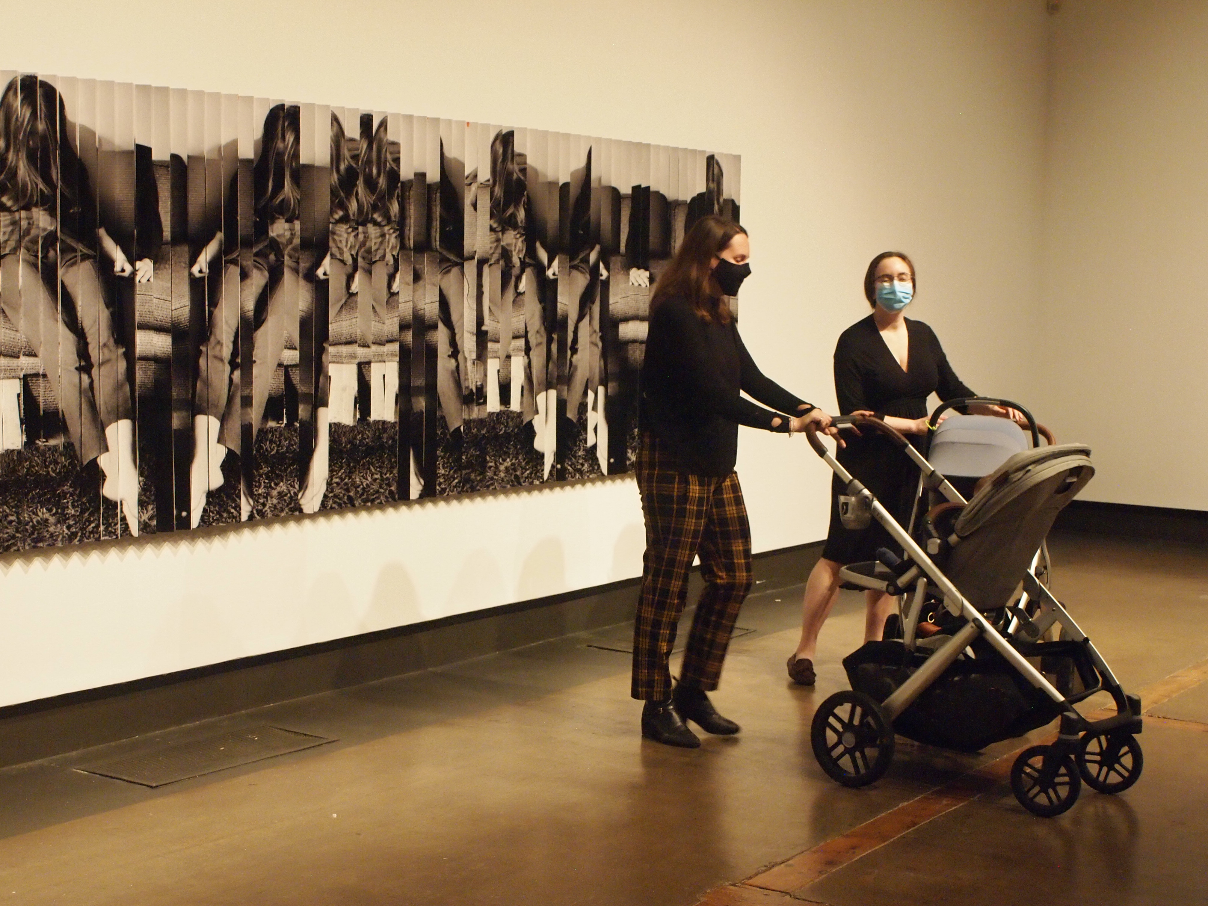 Three mothers with strollers stand together at the end of the Corridor Gallery