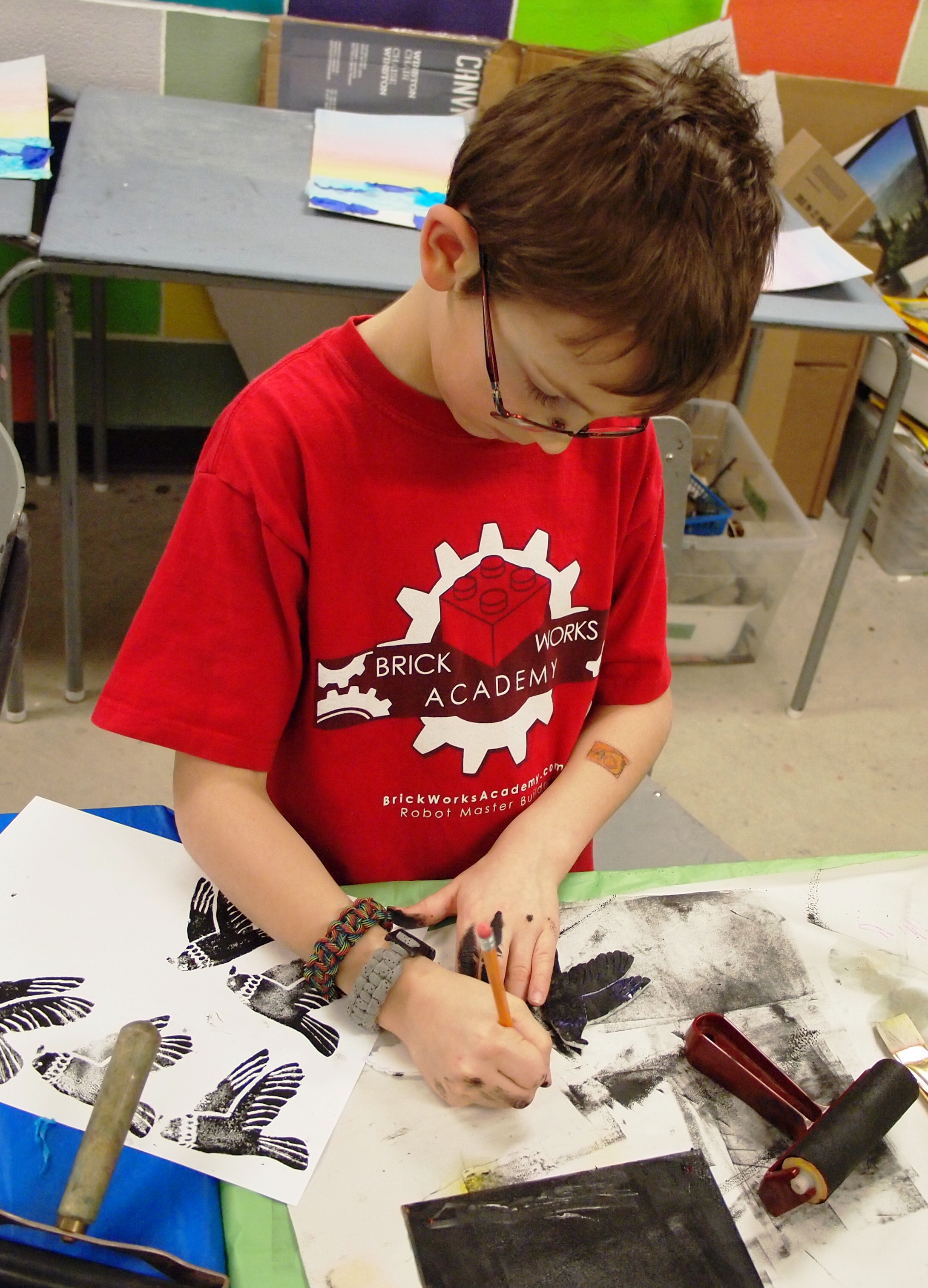 A young boy making multiple bird prints in the KWAG studio