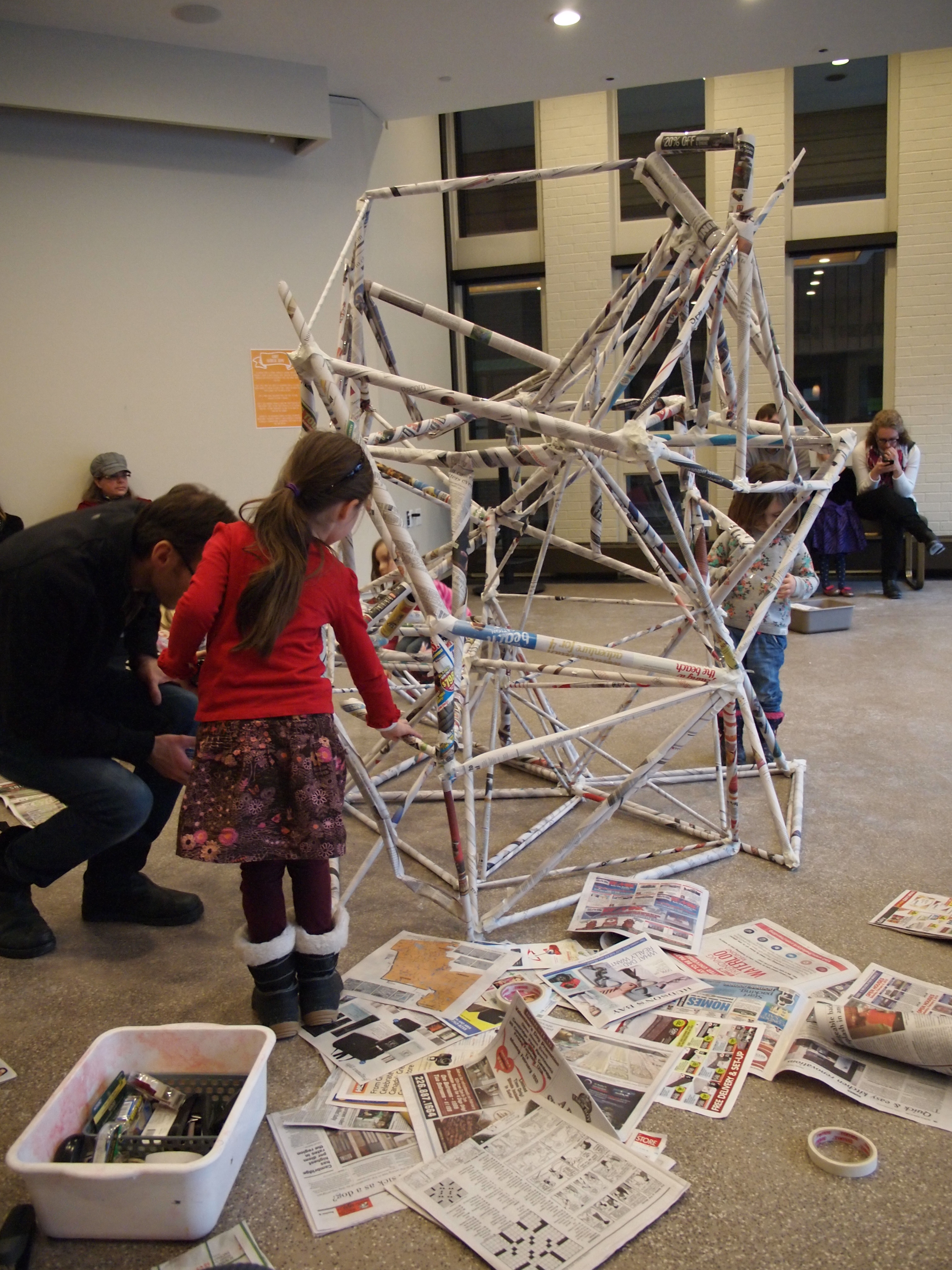 A child works on creating a large papier mache sculpture that fills the centre of the activity space.