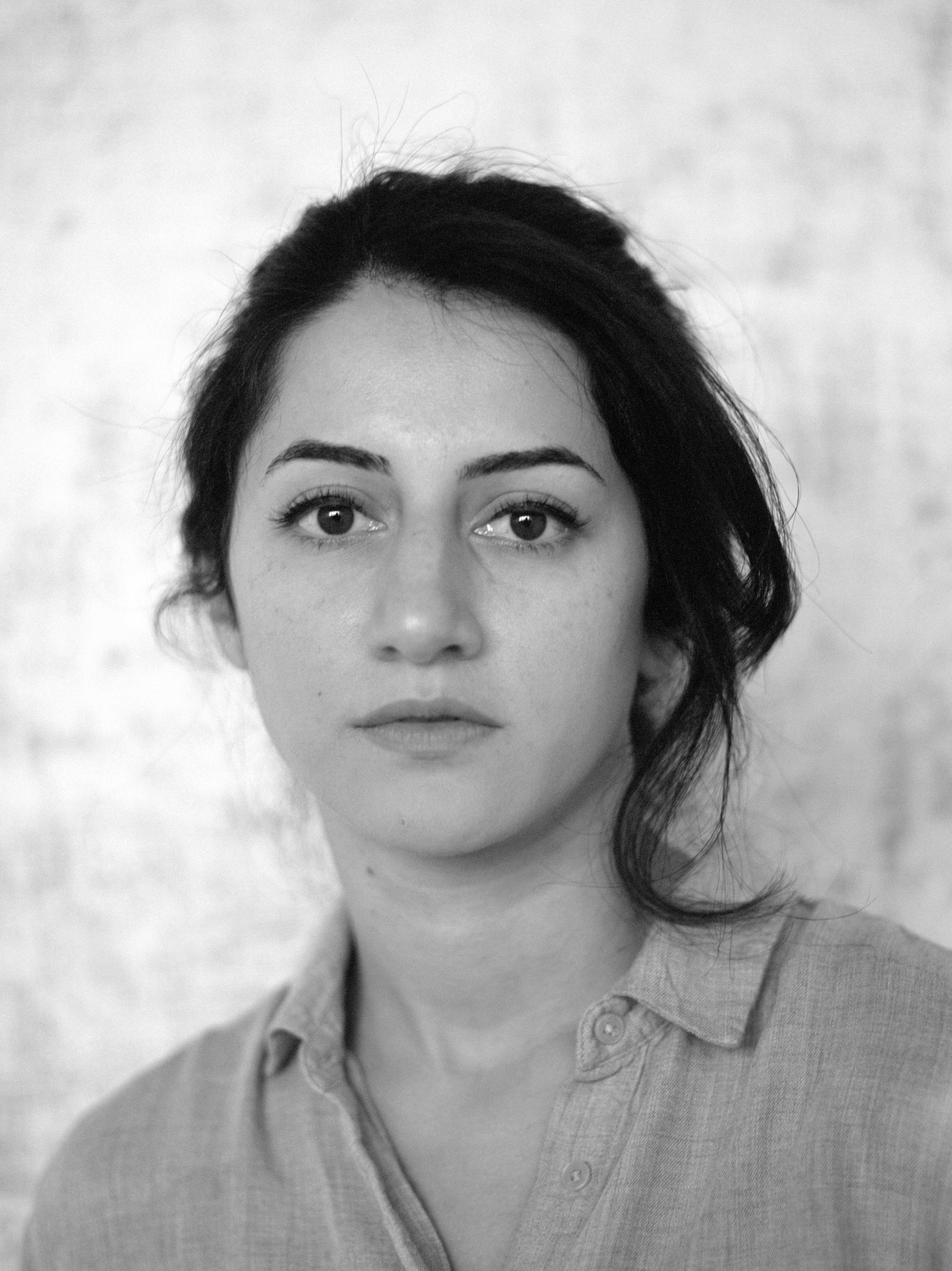 Black and white photo of Pardiss Amerian, a young woman with dark hair and eyes wearing a collared shirt