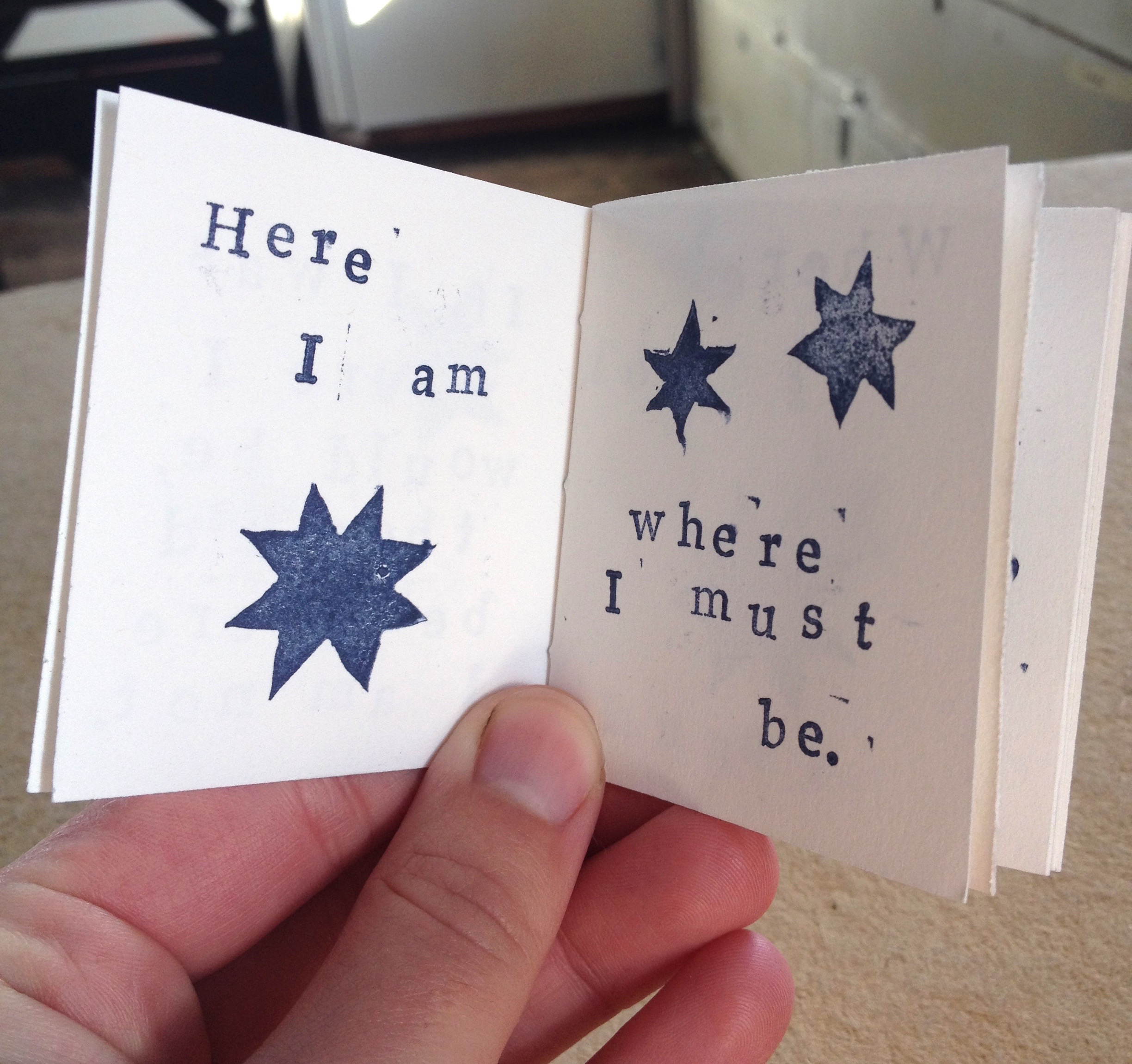 View of an opened zine featuring stamped text and star shapes