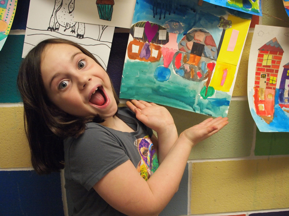 Young girl smiling in front of her watercolor painting