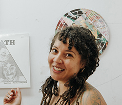 photo of person smiling in front of a circular mosaic