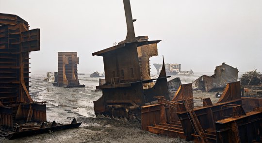 Large metal shipwreck on a shallow water beach