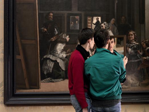 Two Mirrors by Adad Hannah shows two young men holding up a mirror to their own reflections while standing before Velazquez' painting Las Meninas