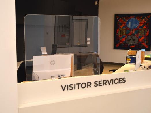 Photo of KWAG Visitor Services desk with plexiglass shield installed