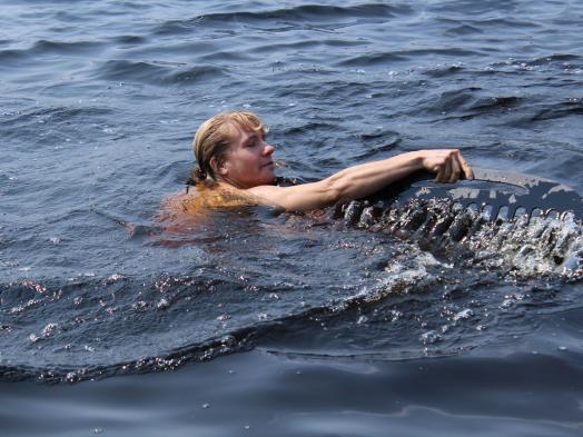 Woman swimming in water with giant black comb