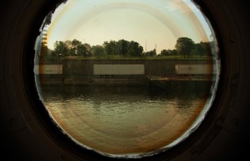 photograph through a circular glass window at the lakeshore