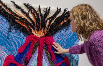 Close-up shot of a person touching a tufted volcano