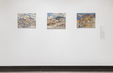 View of a white wall with three  landscape paintings