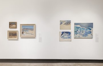 View of a white wall with six  landscape paintings