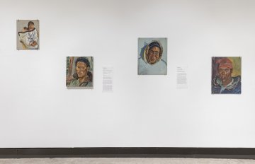 View of a white wall with four  landscape paintings