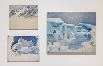 View of a white wall with three  landscape paintings