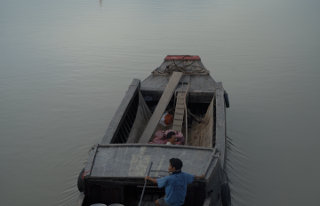 a photograph of a boat on a foggy lake
