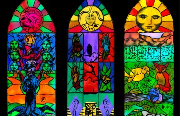 Three stained-glass windows displaying a variety of trees, animals, and magical imagery