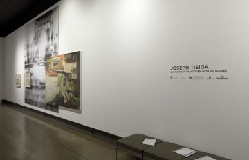 installation view of exhibition showcasing title of exhibition on wall along with a few large images hung on the wall