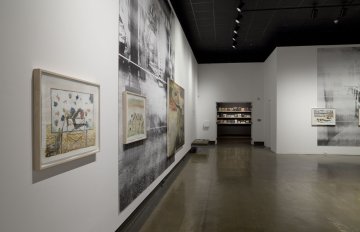 installation view of exhibition with large images on two walls