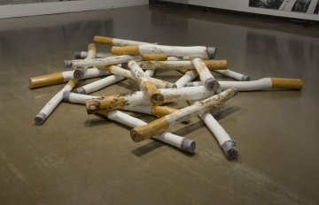 large sculpture of cigarettes in the middle of the exhibition floor 