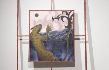 gallery view of exhibition installation. focused on a painting of a leopard jumping at a red moon