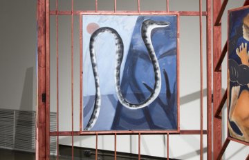 gallery view of exhibition installation. Focus on a painting of a blue snake