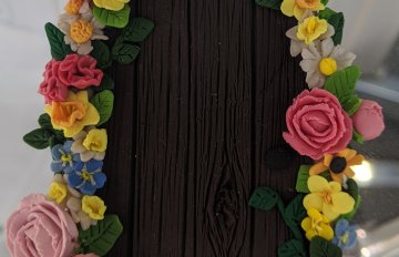 sculpture of a door framed in pink and yellow roses