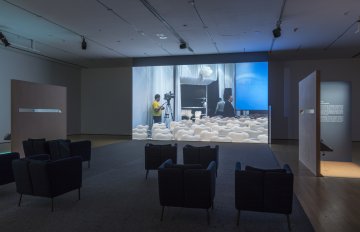 installation view of art exhibition with movie projected on wall