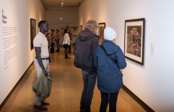 Side view of people viewing a Burtynsky framed photo