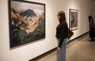 Side view of people viewing a Burtynsky framed photo