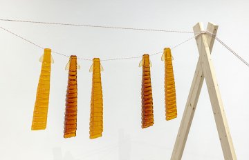 Pitsiit (drying fish) shaped candy, amber in color, hanging on a rope