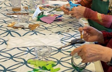 Side view of multiple participants' hands arranging materials on a table