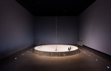 View from afar of the circular concrete foundatin with two birds off th the right front side