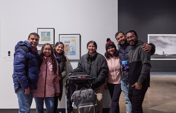 View of a group of people looking at artworks on a white wall