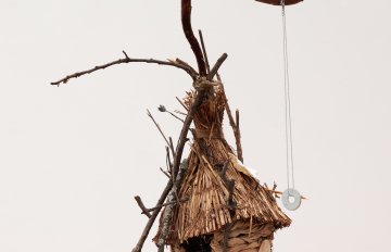 Small dwelling makde of twine, weaving and rocks ina  house shape