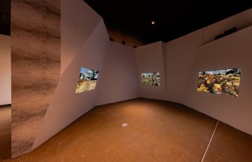 Installation view of all three screens in the exhibition protruding from the walls in the space.