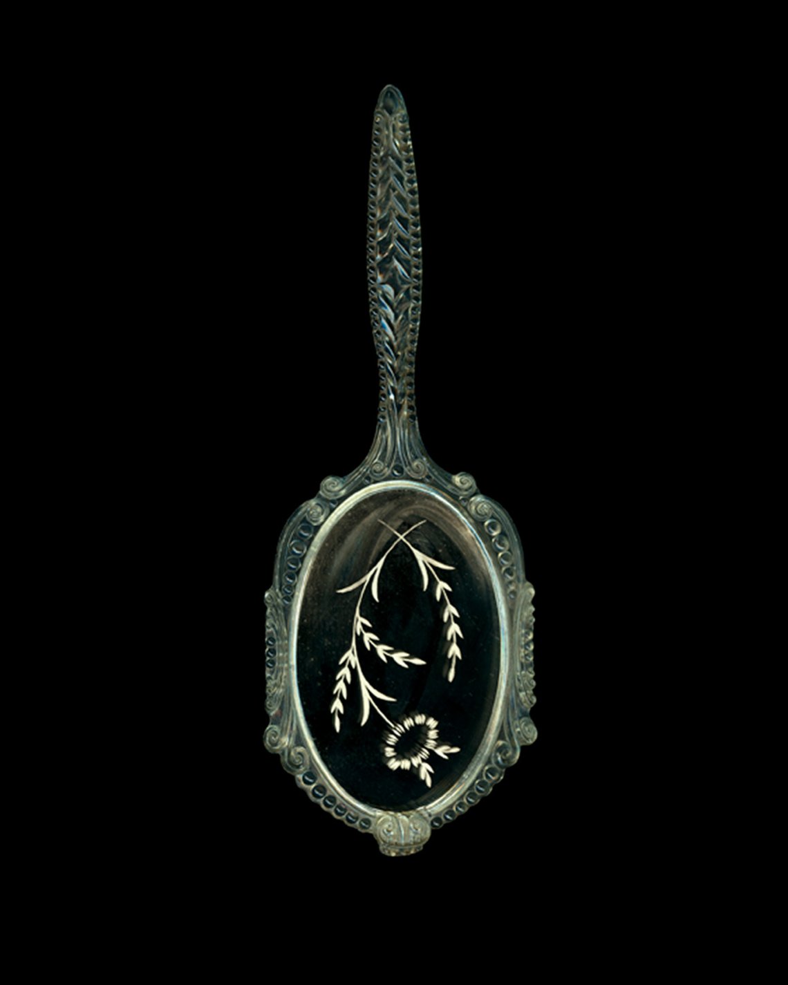 a green hand mirror with flowers painted on the glass