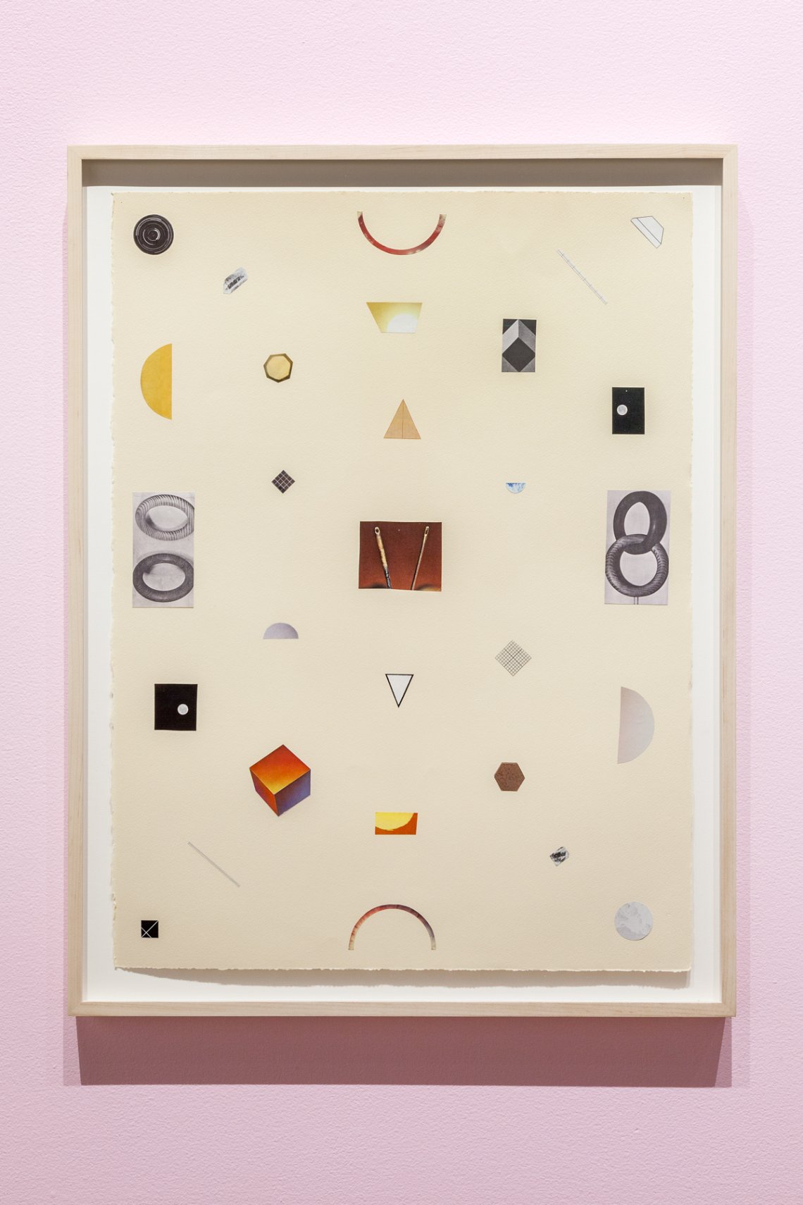 image hung on a pink wall with random shapes and pieces put onto a white backdrop to make a design