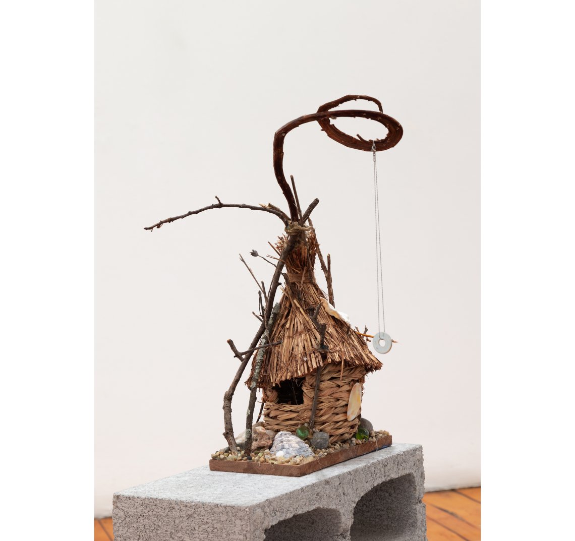 Small dwelling makde of twine, weaving and rocks ina  house shape