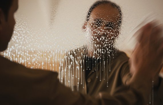 video still of a man cleaning a mirror