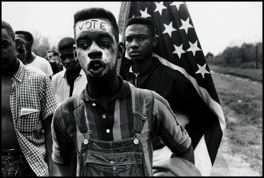 Historical black and white photo of young Black men protesting for the right to vote
