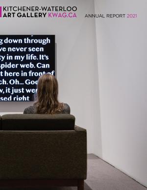 Cover of the 2021 Annual Report featuring a woman seated on a sofa watching a video of white text on a black screen